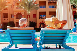 A retired couple spending quality time by the pool.