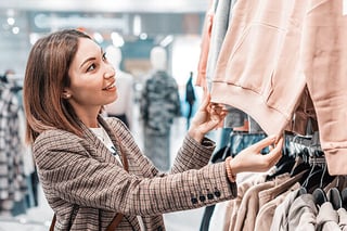 A young woman interested in a sweatshirt.