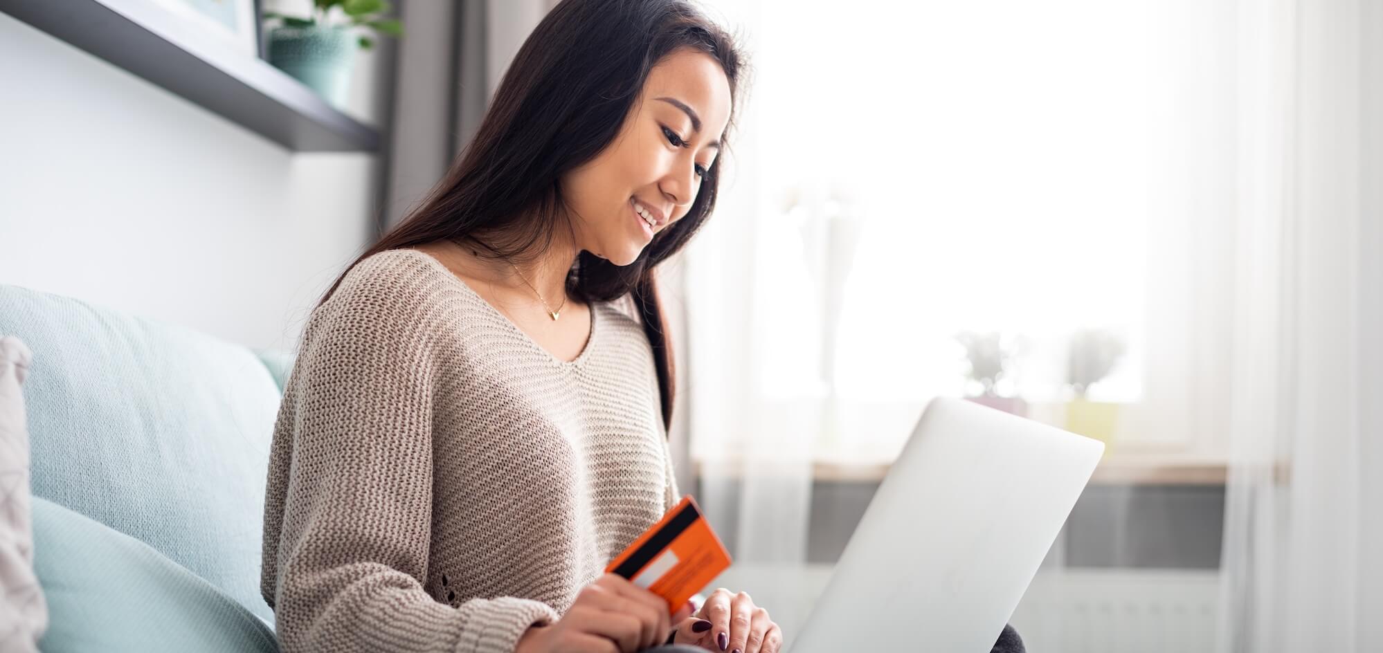 Asian girl making online payment using laptop for shopping at home Asian girl making online payment using laptop for shopping at home
