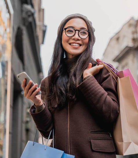 A woman shopping and using her smartphone to manage her credit.